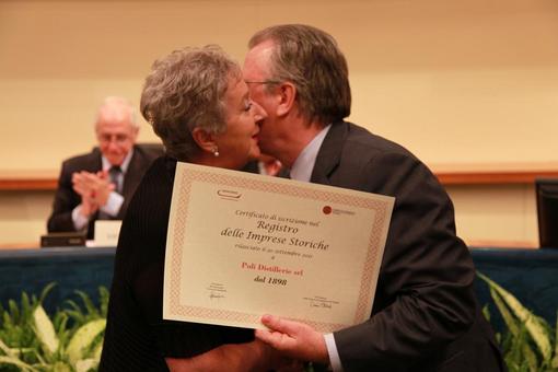 La signora Teresa Poli riceve l' attestato dalle mani del Presidente dell' Associazione Industriali di Vicenza.
